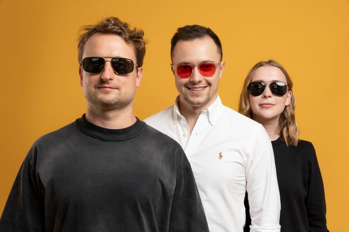 The Flyer One Ventures partner team — Vital Laptenok, Oleksii Yermolenko, and Elena Mazhuha, wearing glasses and standing one behind another